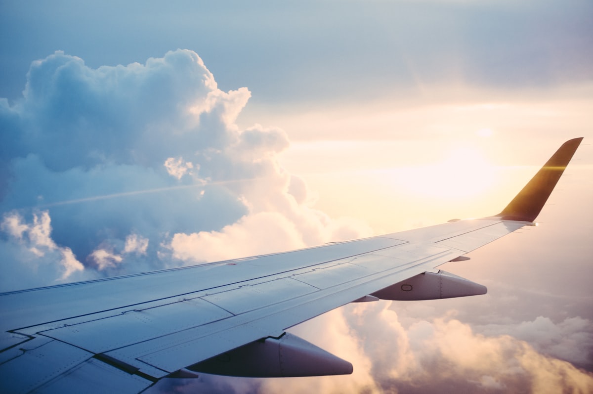 Ala de avión sobre las nubes al atardecer